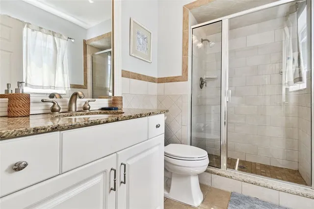 a living room with a black white checkered floor with a gaming machine and dining table