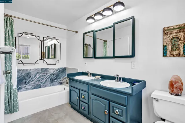 a bathroom with a double vanity sink mirror and bathtub
