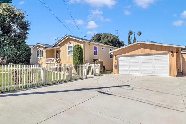 a view of an house with backyard and a tree