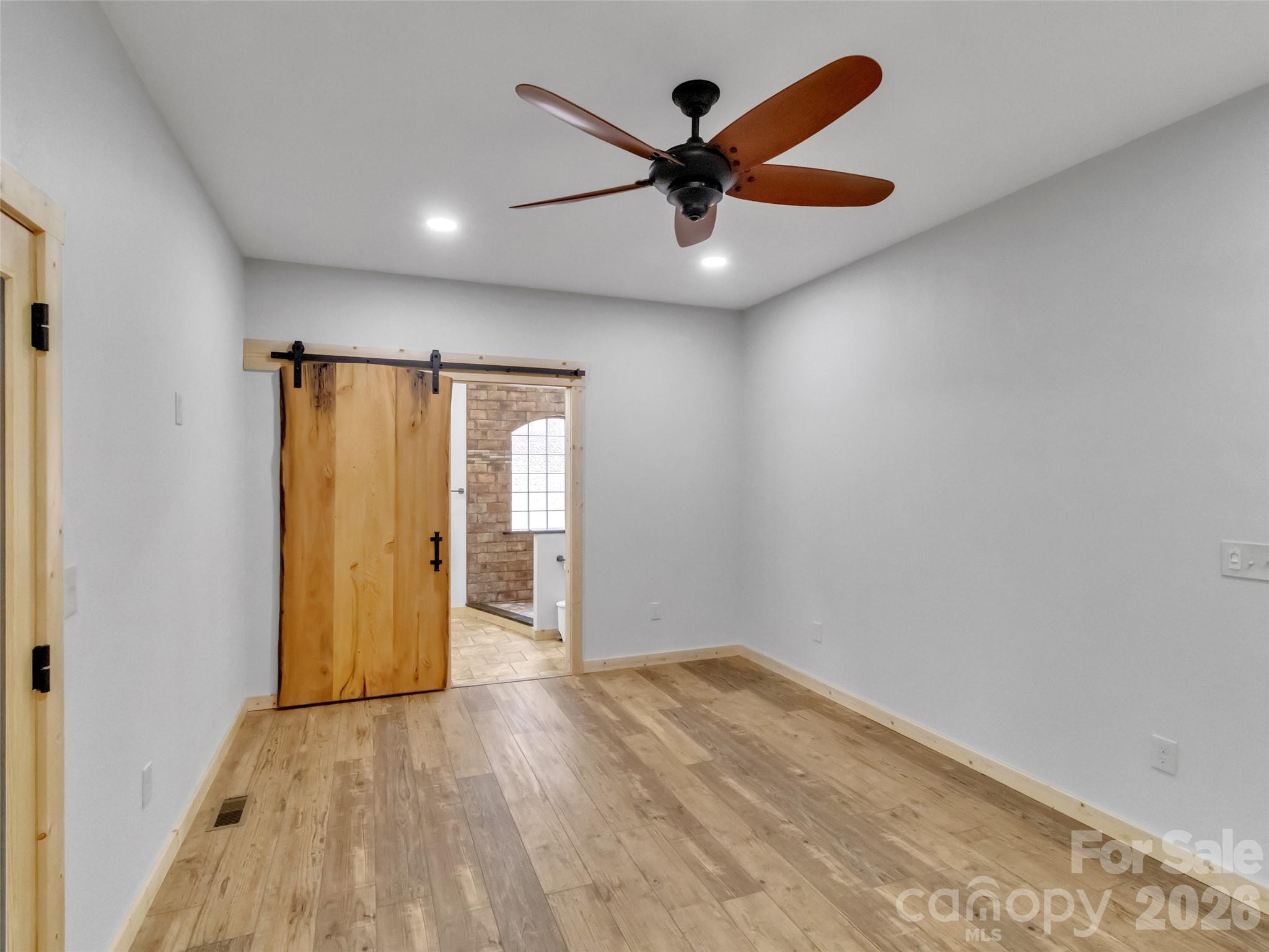 171 Cowtail Cove Clyde, NC 28721 - Photo 12 of 48 a view of empty room with wooden floor and fan