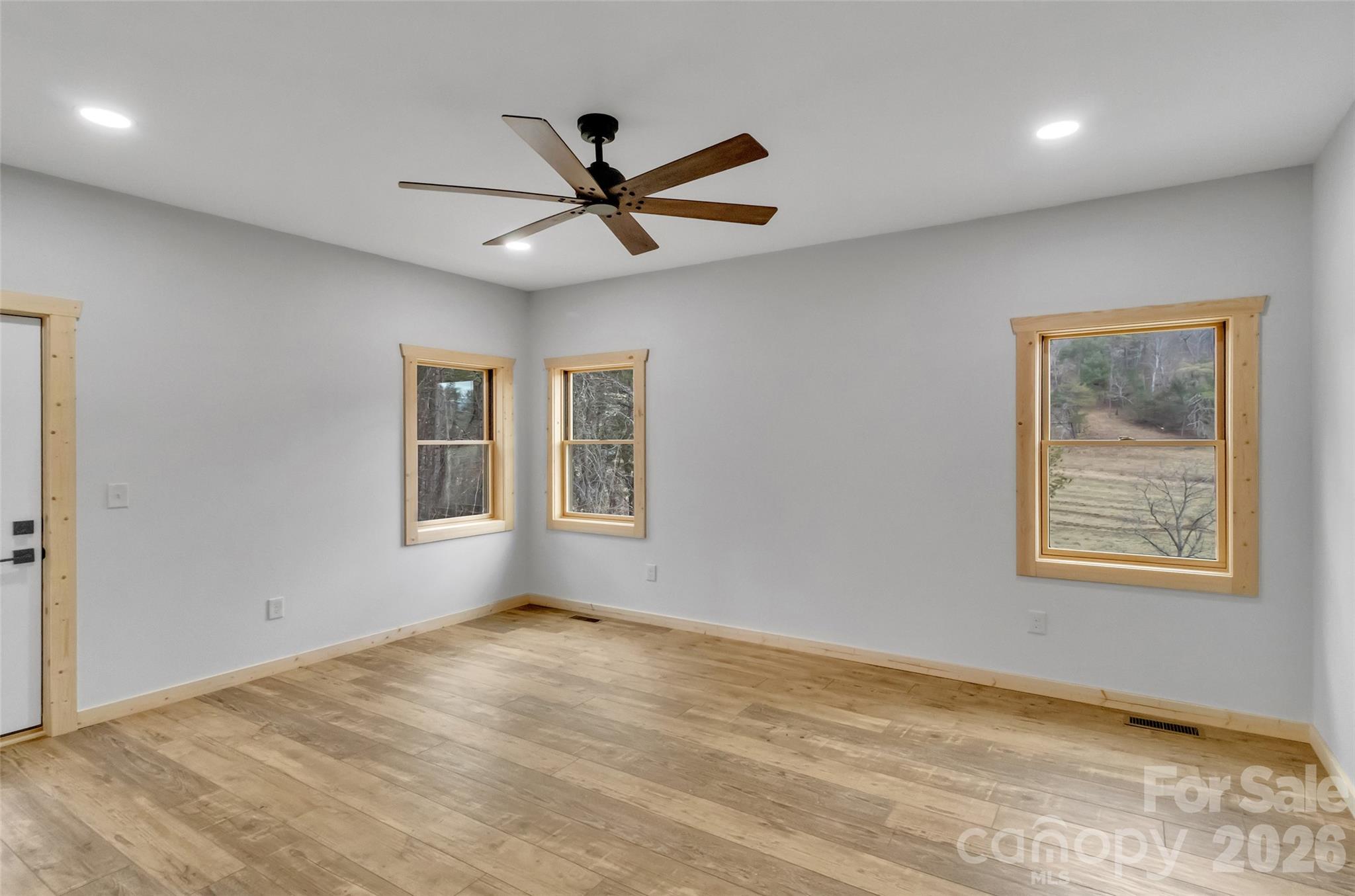 171 Cowtail Cove Clyde, NC 28721 - Photo 16 of 48 a view of empty room with wooden floor and fan