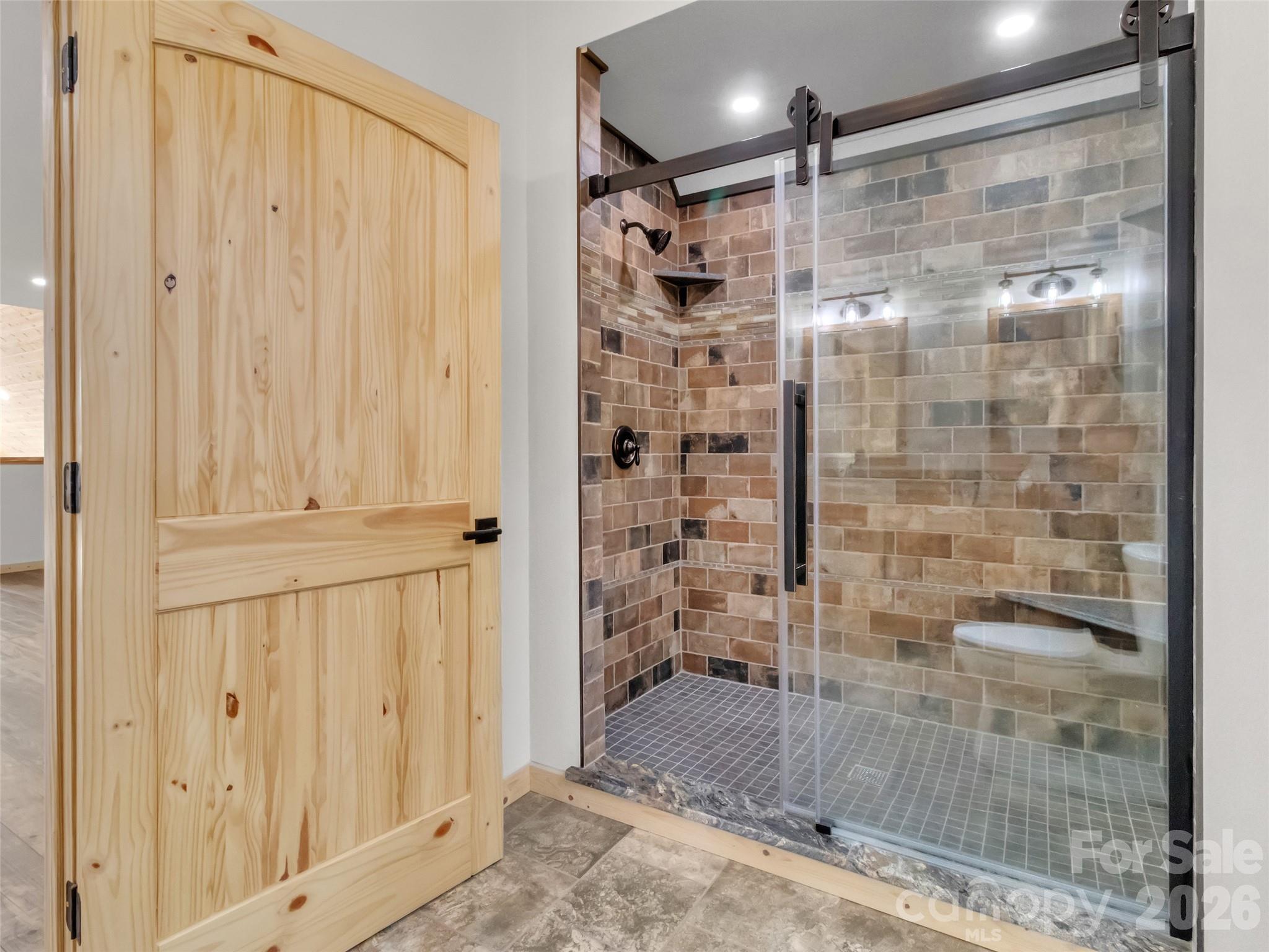 171 Cowtail Cove Clyde, NC 28721 - Photo 31 of 48 a bathroom with a glass shower door