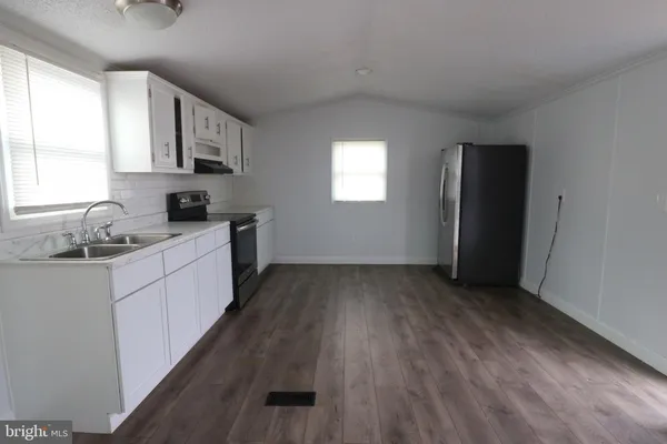 a kitchen with granite countertop a sink stove and cabinets