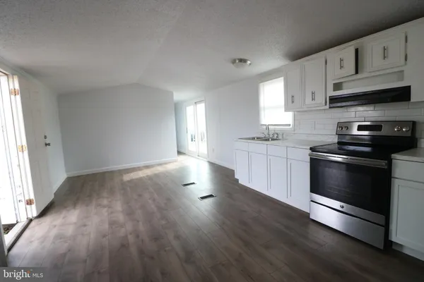 a kitchen with stainless steel appliances white cabinets and wooden floor
