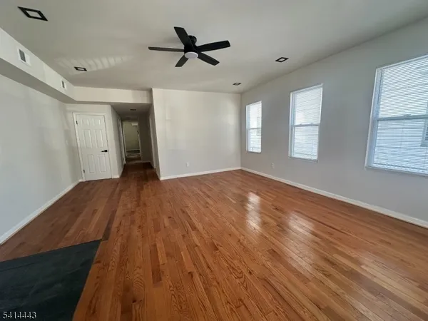 a view of empty room with wooden floor and window