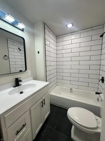 a bathroom with a sink toilet a mirror and shower