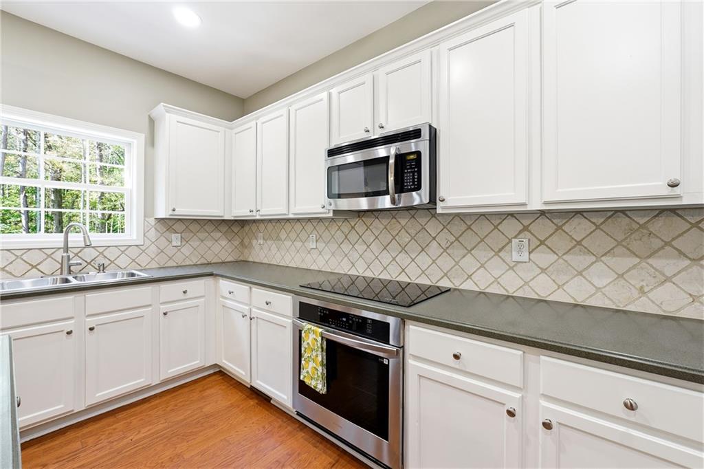 304 Meadowcrest Circle Canton, GA 30115 - Photo 14 of 50 a kitchen with granite countertop white cabinets stainless steel appliances and a sink