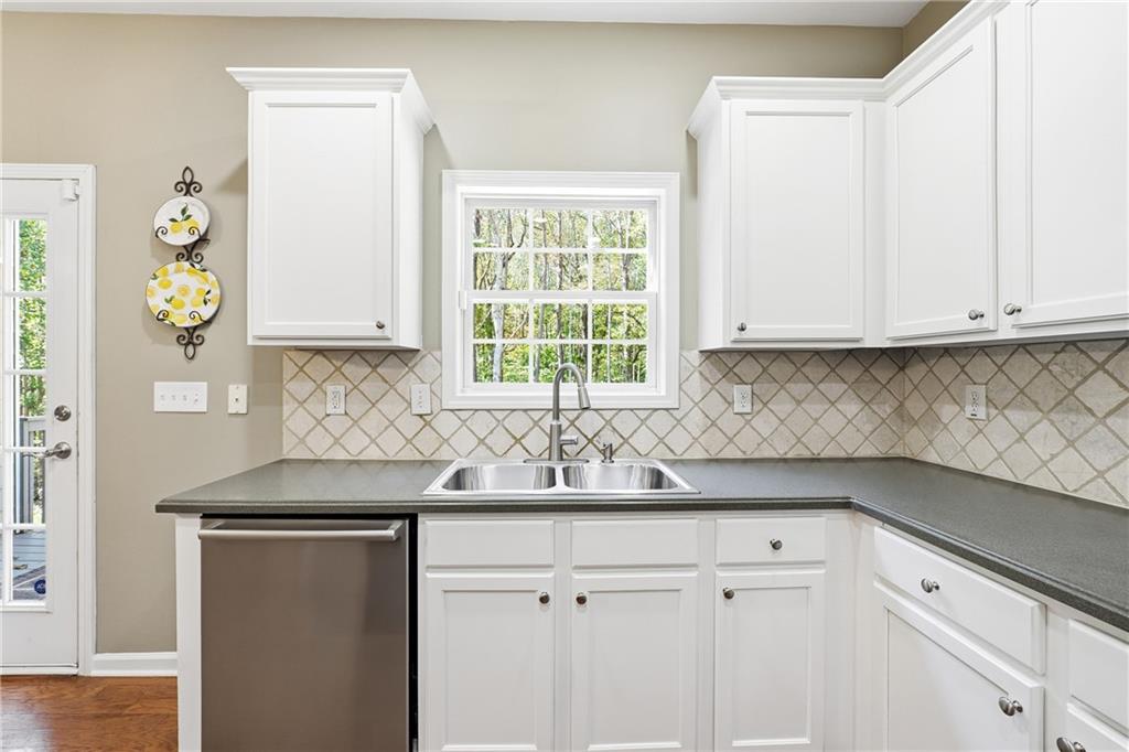 304 Meadowcrest Circle Canton, GA 30115 - Photo 15 of 50 a kitchen with stainless steel appliances granite countertop white cabinets sink and window