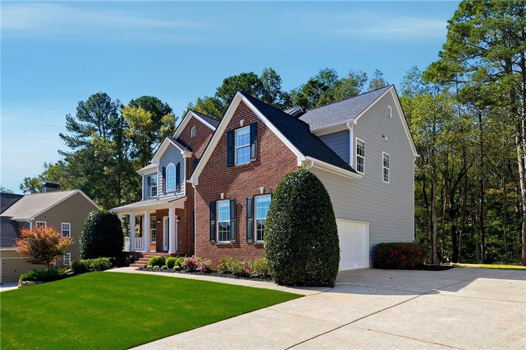 304 Meadowcrest Circle Canton, GA 30115 - Photo 3 of 50 a view of a white house next to a yard with big trees