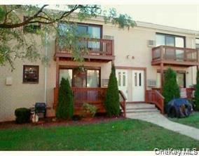 122 Sneden Place West, Unit 122 Spring Valley, NY 10977 - Photo 1 of 20 View of front of house with a balcony, a front yard, and stucco siding
