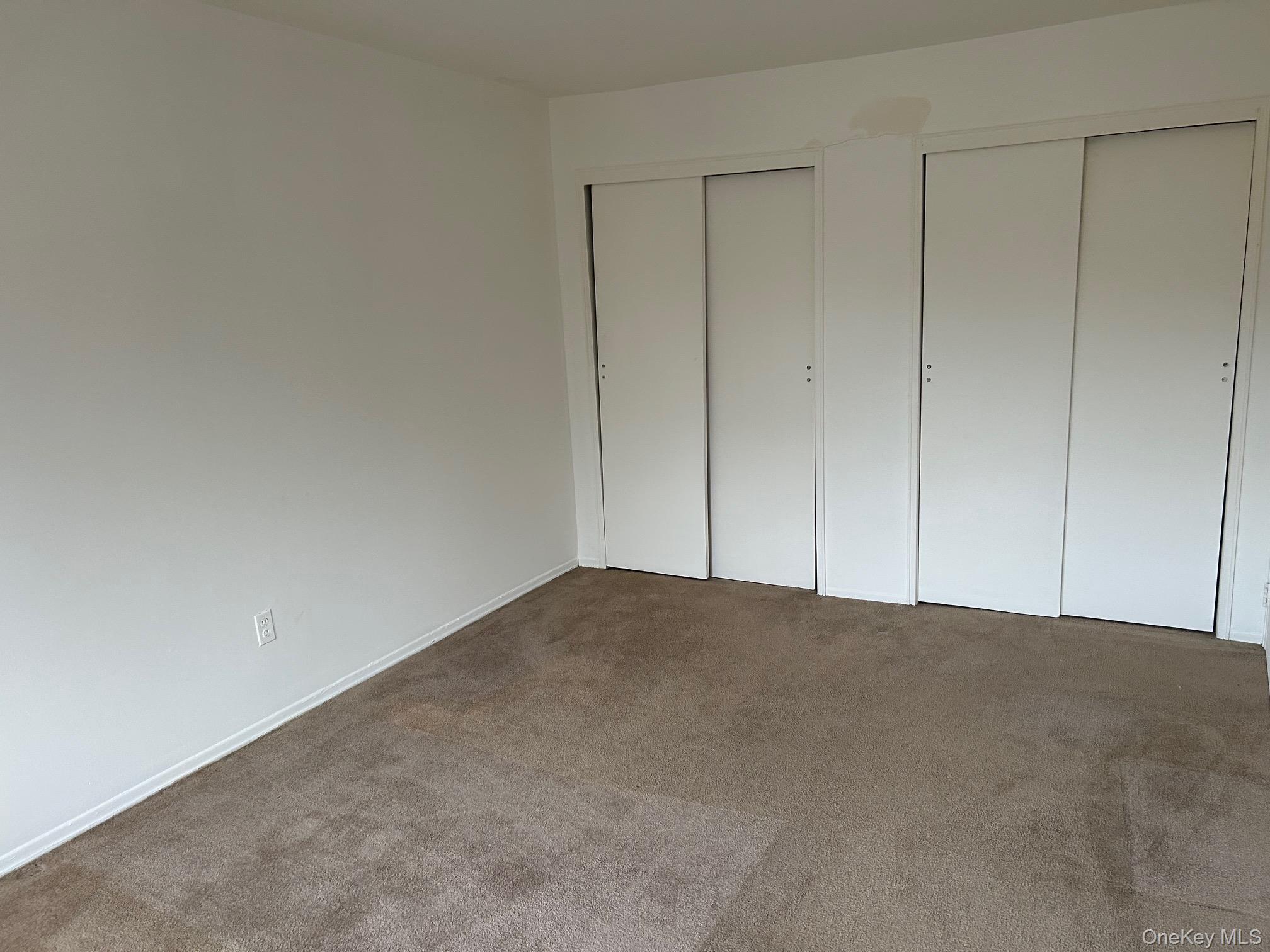 122 Sneden Place West, Unit 122 Spring Valley, NY 10977 - Photo 12 of 20 Unfurnished bedroom featuring two closets and carpet floors