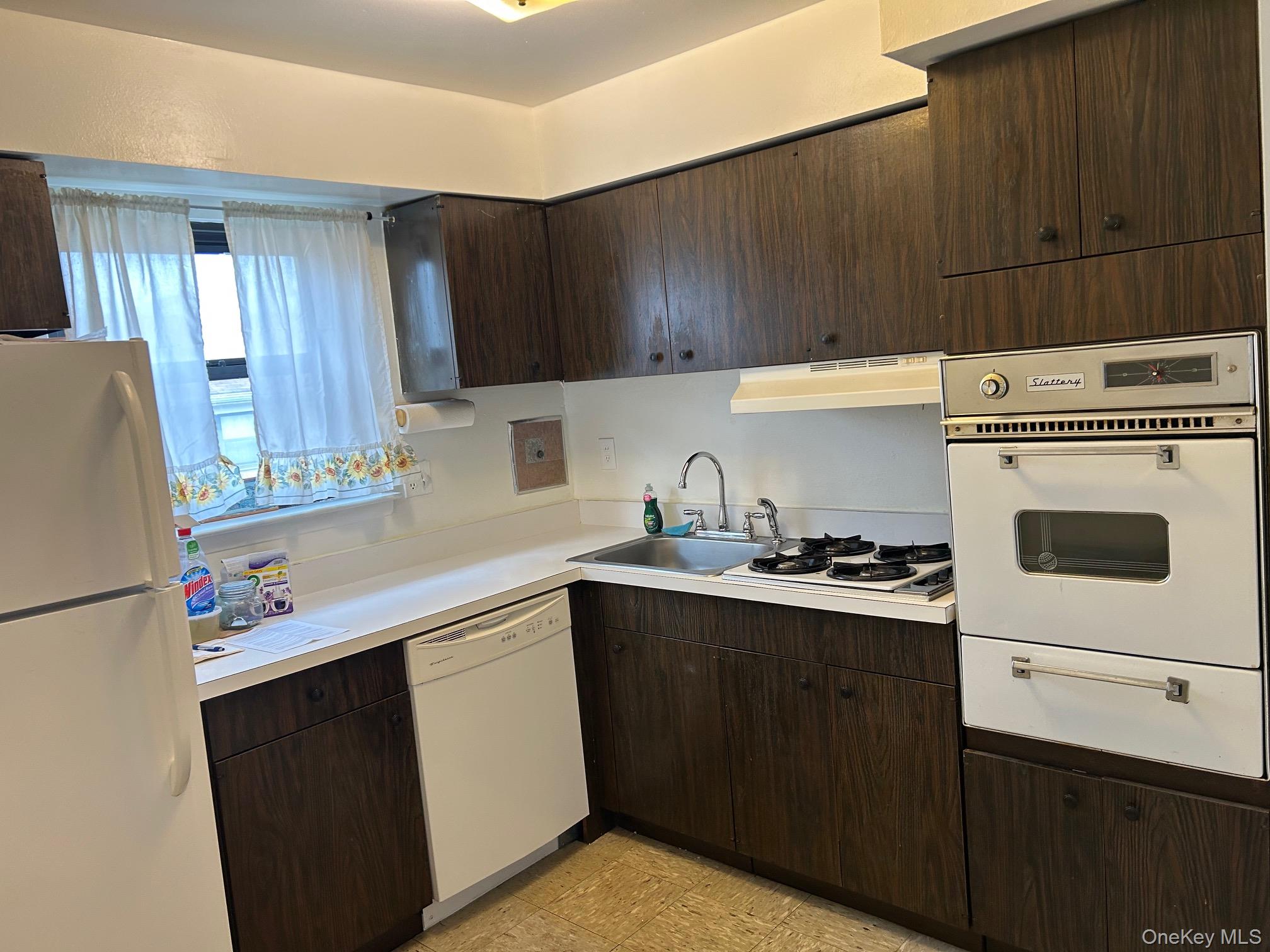 122 Sneden Place West, Unit 122 Spring Valley, NY 10977 - Photo 7 of 20 Kitchen featuring dark brown cabinets, white appliances, light countertops, and a warming drawer