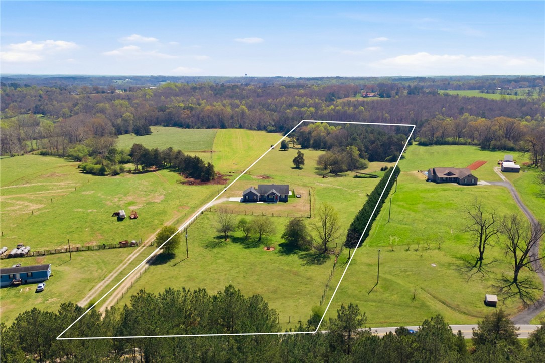 426 Oak Creek Road Seneca, SC 29678 - Photo 46 of 50 Expansive green acreage with distant trees and scattered homes create a peaceful rural setting.
