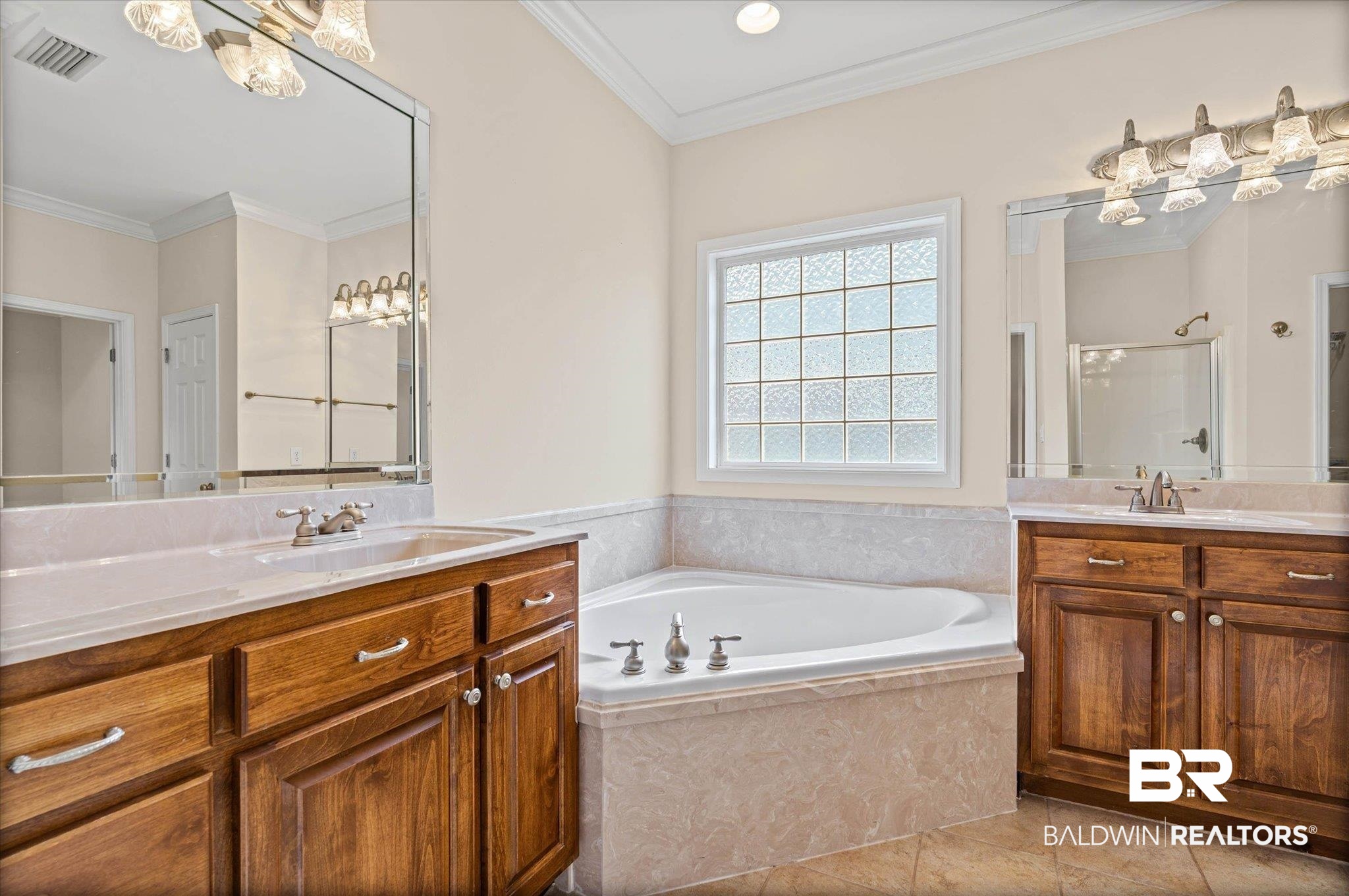 1003 Weatherby Street South Saraland, AL 36571 - Photo 26 of 31 Full bath with ornamental molding, two vanities, a stall shower, a bath, and light tile patterned floors