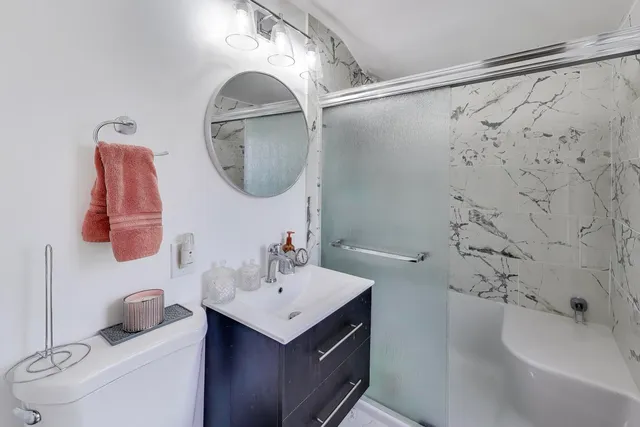 a bathroom with a sink vanity mirror and toilet