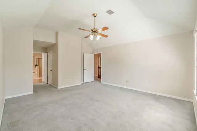 an empty room with windows and fan