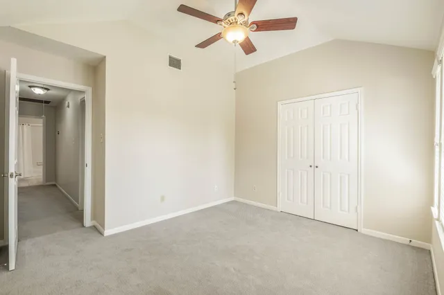 an empty room with windows and ceiling fan