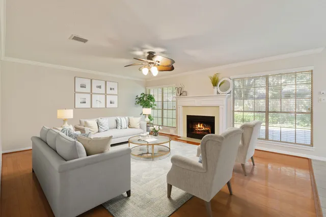 a living room with furniture a fireplace and a large window