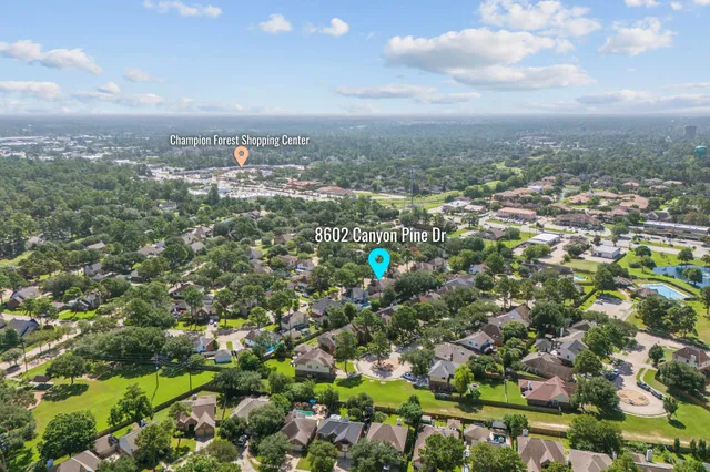 an aerial view of residential houses with outdoor space and trees