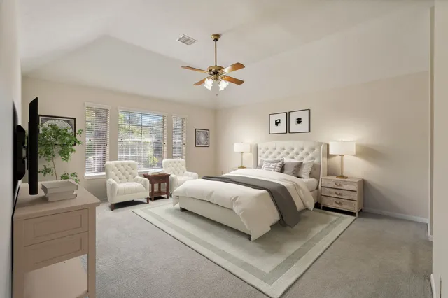 a bedroom with bed couches and a flat tv screen