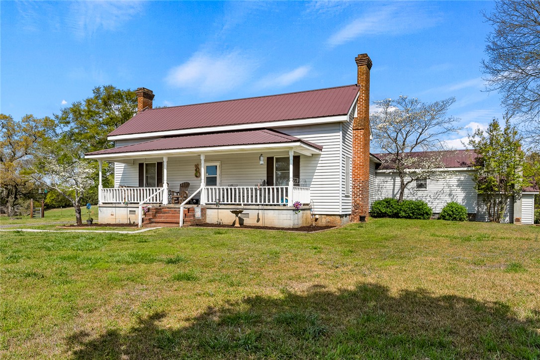 801 Princeton Highway Honea Path, SC 29654 - Photo 1 of 49 This charming home features a welcoming porch, lush green lawn, and mature trees, creating a serene setting.