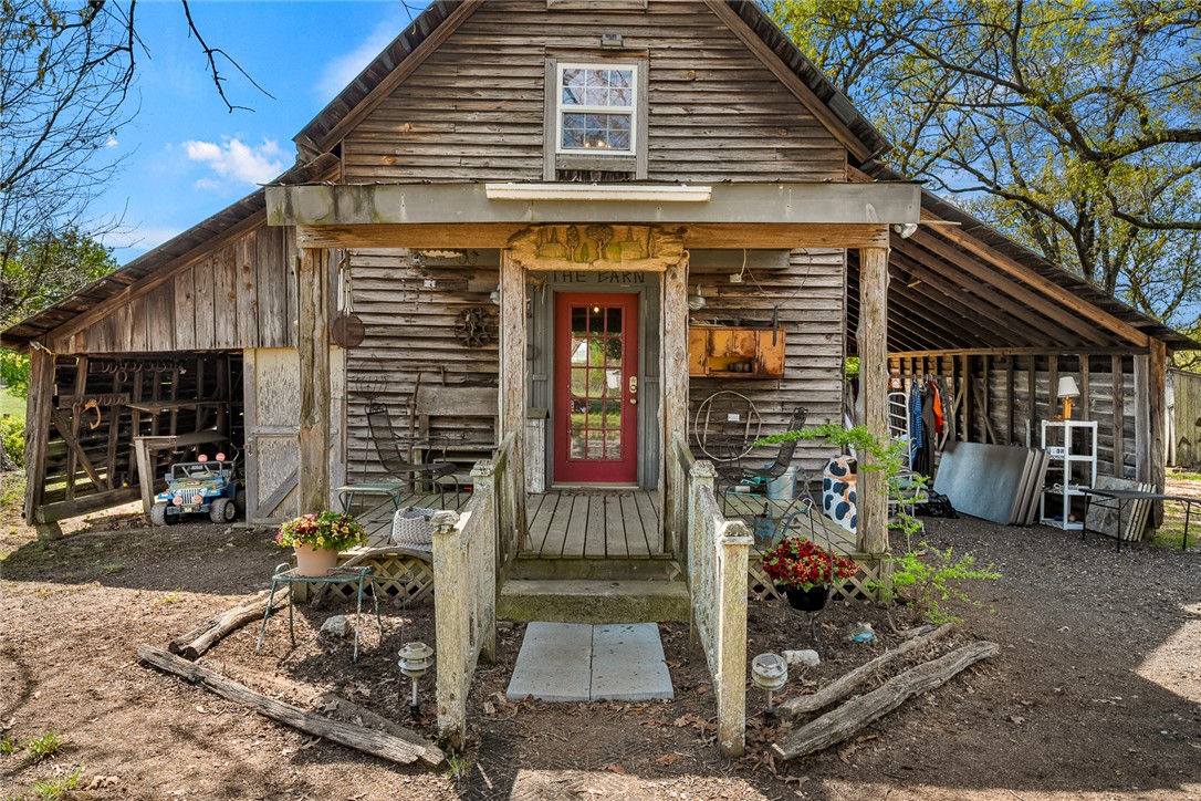 801 Princeton Highway Honea Path, SC 29654 - Photo 28 of 49 This rustic wood-sided structure features a charming red door and an inviting porch.