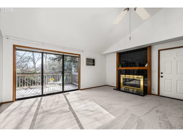 a view of an empty room with furniture and a window