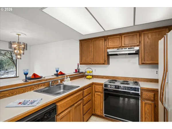 a kitchen with stainless steel appliances a sink dishwasher stove and white cabinets