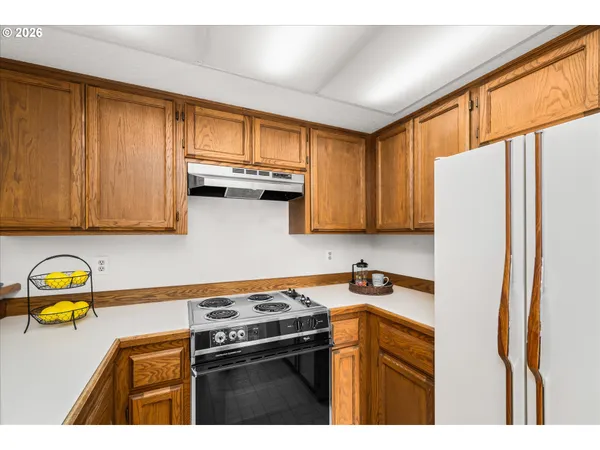 a kitchen with stainless steel appliances granite countertop a refrigerator a stove top oven a sink and dishwasher