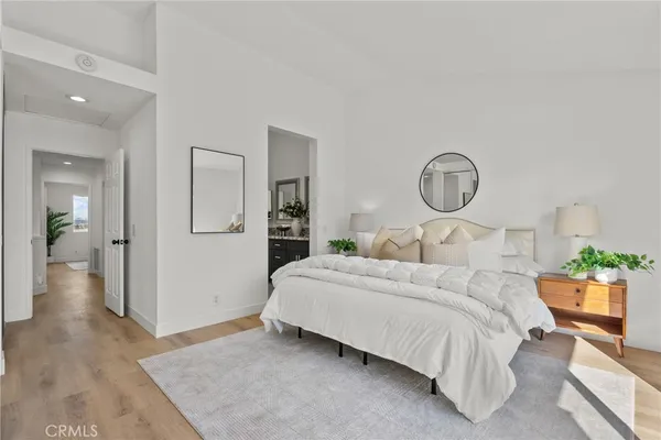 a bedroom with a bed a mirror and lamp
