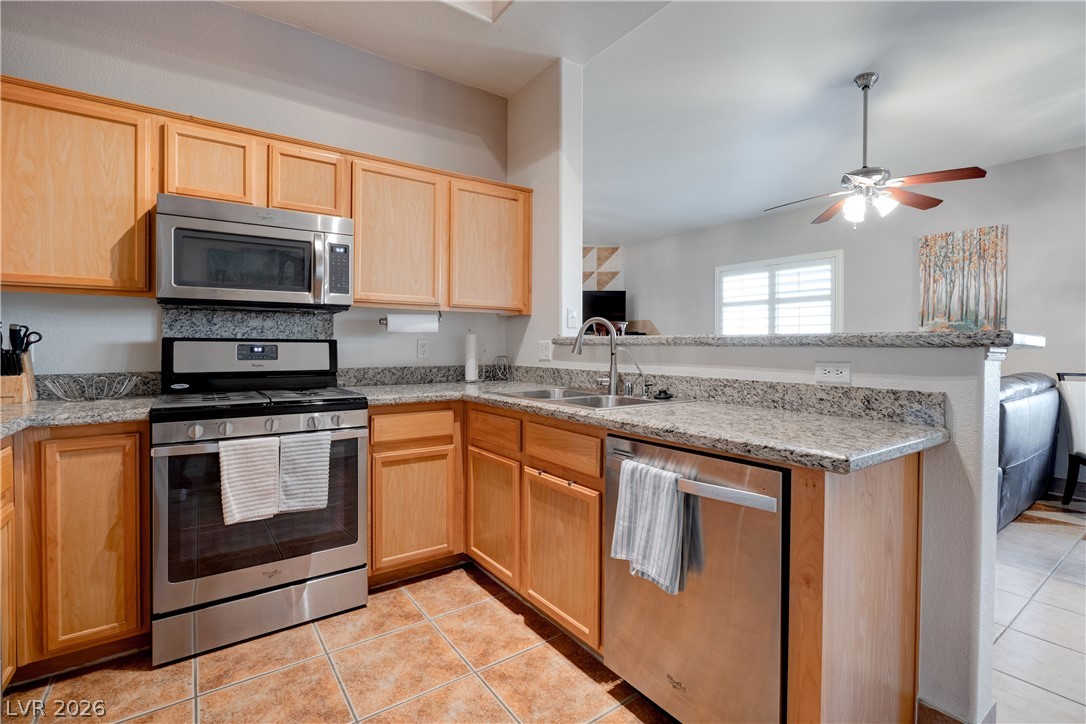 2305 West Horizon Ridge Parkway, Unit 224 Henderson, NV 89052 - Photo 15 of 41 This modern kitchen features warm wood cabinetry, stainless steel appliances, and durable granite countertops.