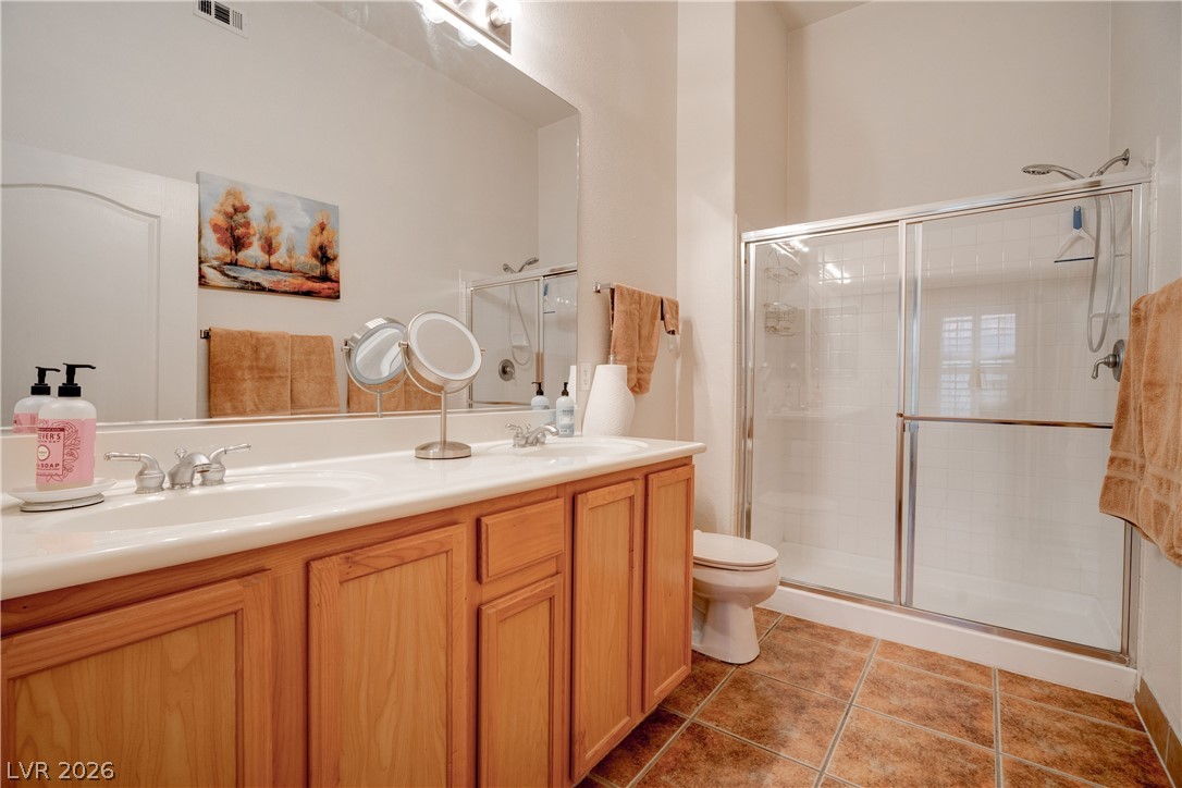 2305 West Horizon Ridge Parkway, Unit 224 Henderson, NV 89052 - Photo 21 of 41 This primary bathroom features a double vanity and a glass-enclosed shower, offering functionality and convenience.