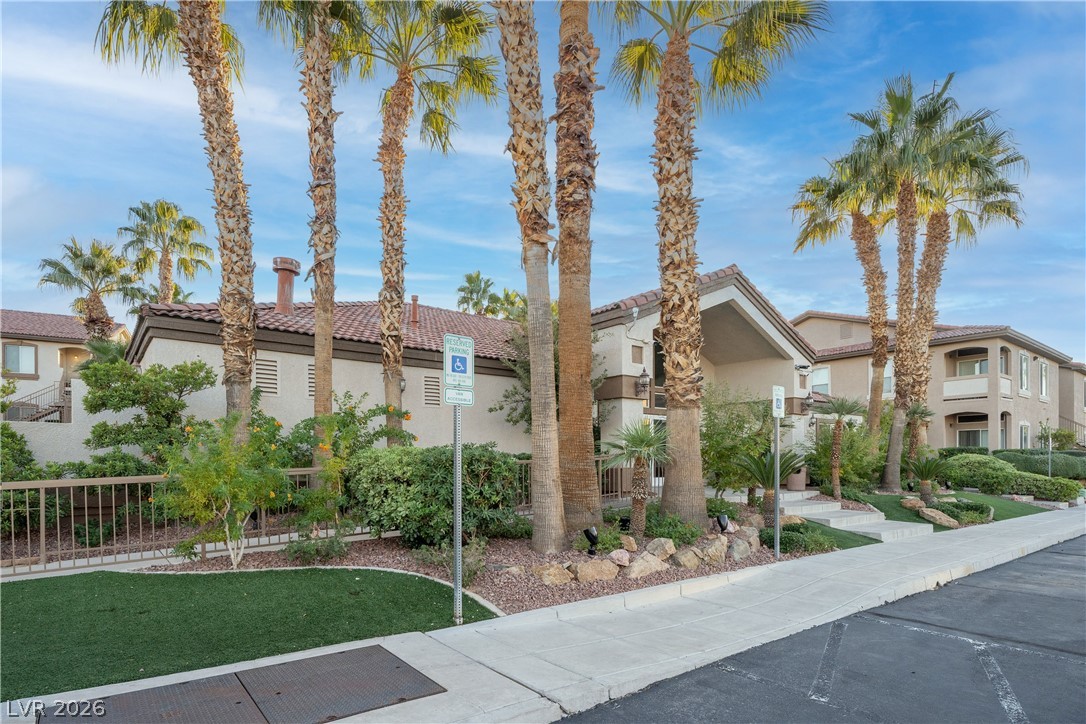2305 West Horizon Ridge Parkway, Unit 224 Henderson, NV 89052 - Photo 38 of 41 This residential building features a classic tile roof and an inviting entrance, surrounded by lush landscaping.
