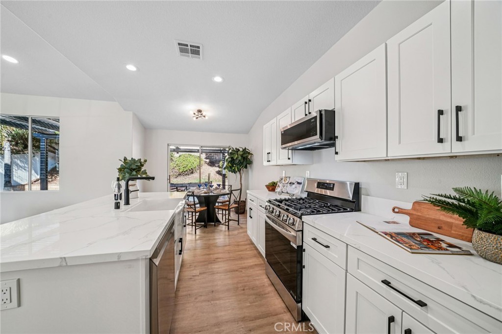 12842 Tilden Drive Rancho Cucamonga, CA 91739 - Photo 17 of 71 a kitchen with stainless steel appliances kitchen island granite countertop a stove a sink and a refrigerator