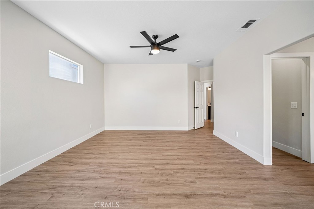 12842 Tilden Drive Rancho Cucamonga, CA 91739 - Photo 29 of 71 a view of an empty room with wooden floor and a ceiling fan