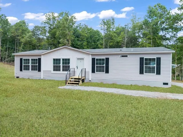 a view of a house with a backyard and a patio