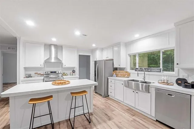 a kitchen with stainless steel appliances kitchen island granite countertop a sink and cabinets