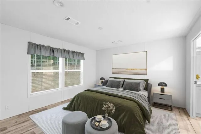 a bedroom with a bed and wooden floor