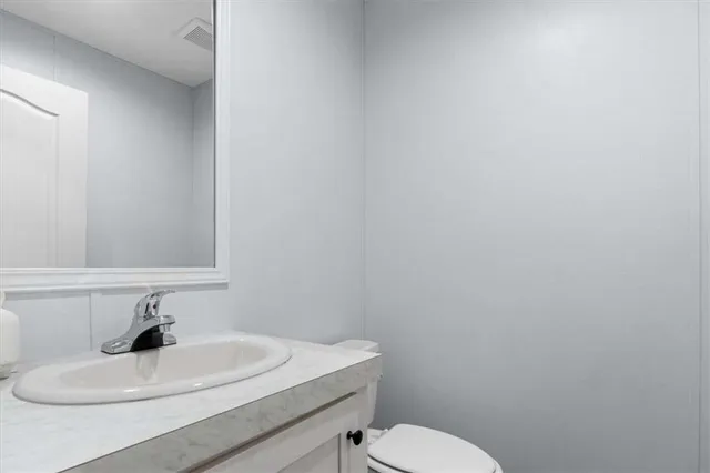 a bathroom with a sink a toilet and mirror