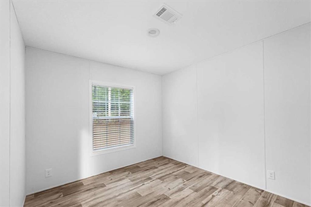 277 Napier Road Southwest Eatonton, GA 31024 - Photo 26 of 34 a view of an empty room with wooden floor and a window