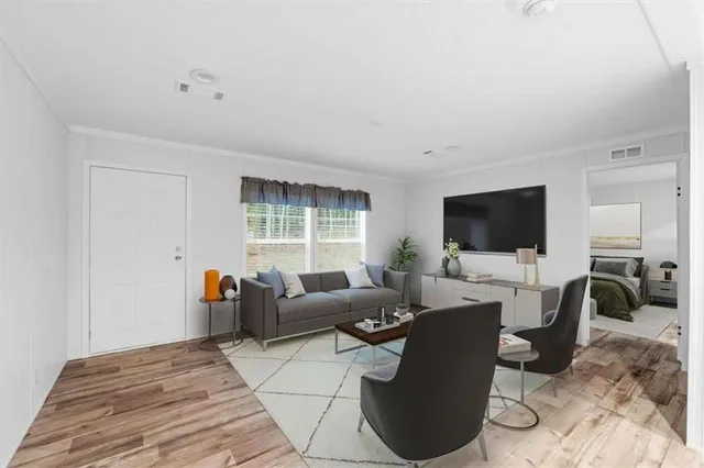 a living room with furniture a flat screen tv and a floor to ceiling window