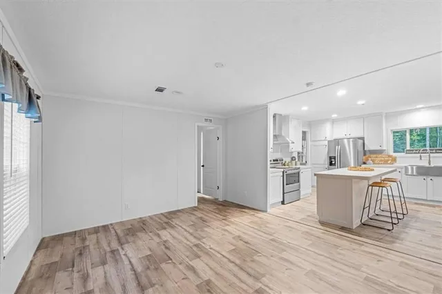 a view of kitchen with wooden floor and electronic appliances
