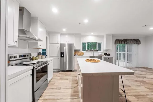 a kitchen with stainless steel appliances a refrigerator a sink a stove and cabinets