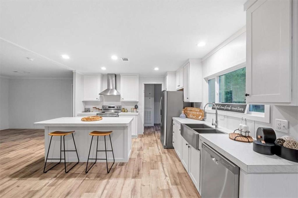277 Napier Road Southwest Eatonton, GA 31024 - Photo 10 of 34 a kitchen with kitchen island a wooden floor and white appliances