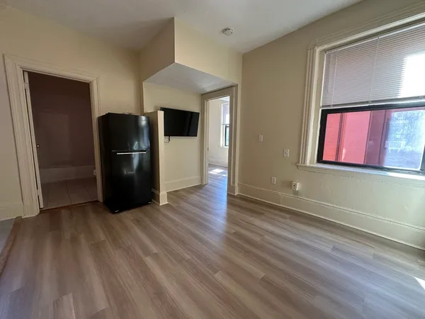 a view of a refrigerator in kitchen and wooden floor