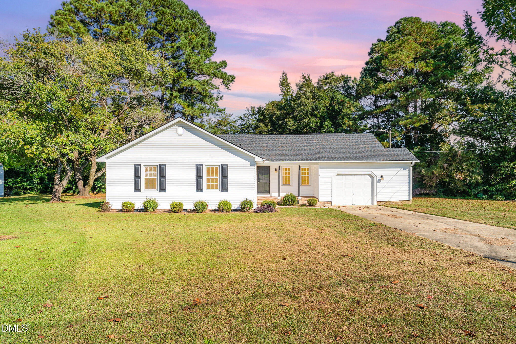 a view of a house with a yard and large tree