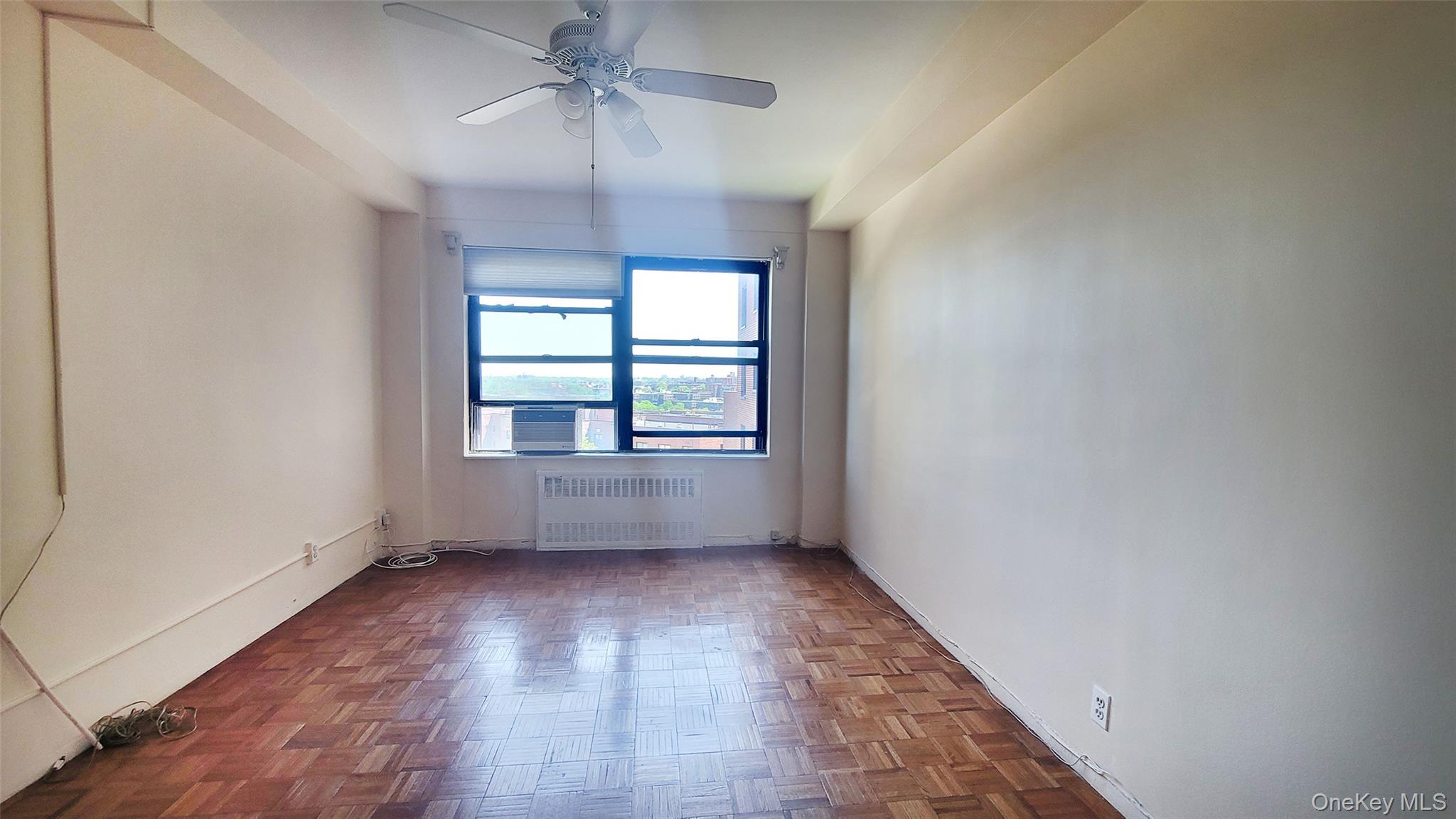99-72 66th Road, Unit 7AA Queens, NY 11374 - Photo 12 of 19 Unfurnished room with radiator heating unit, a ceiling fan, cooling unit, and baseboards