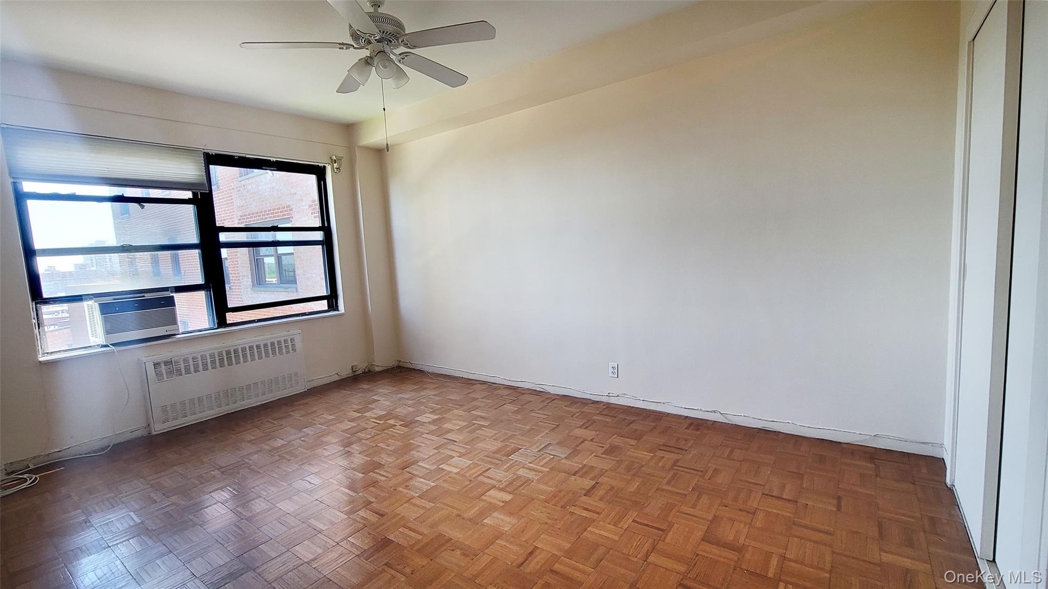 99-72 66th Road, Unit 7AA Queens, NY 11374 - Photo 13 of 19 Spare room featuring radiator, a ceiling fan, baseboards, and cooling unit