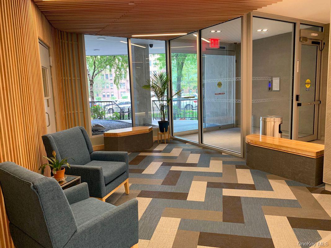 99-72 66th Road, Unit 7AA Queens, NY 11374 - Photo 17 of 19 Community lobby featuring a wall of windows