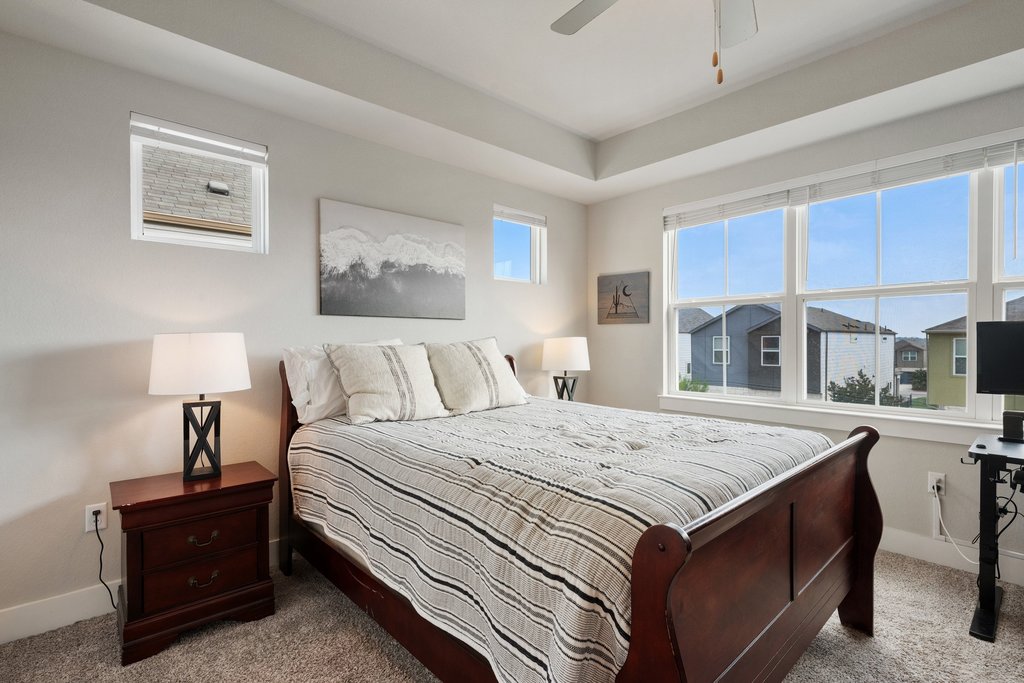 7403 Travertine Spring Drive, Unit 117 Austin, TX 78744 - Photo 25 of 37 A well-lit bedroom features plush carpeting, high ceilings, and ample natural light from generously sized windows.